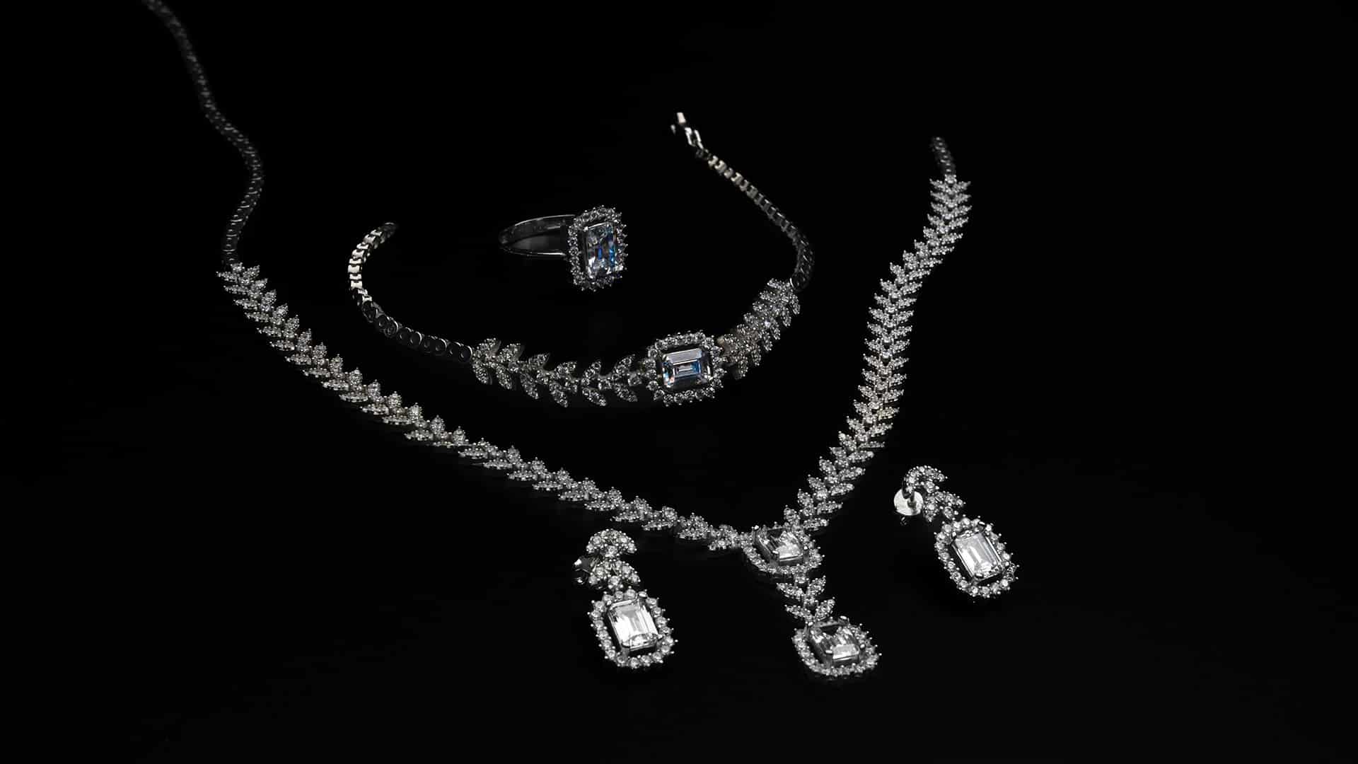 Gem-set jewellery on a dark background in our investing in diamonds guide